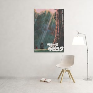 May include: A framed poster with Japanese text and artwork from the animated film "Castle in the Sky." The artwork shows a forest scene with figures and a large tree. The poster is mounted on a white wall.