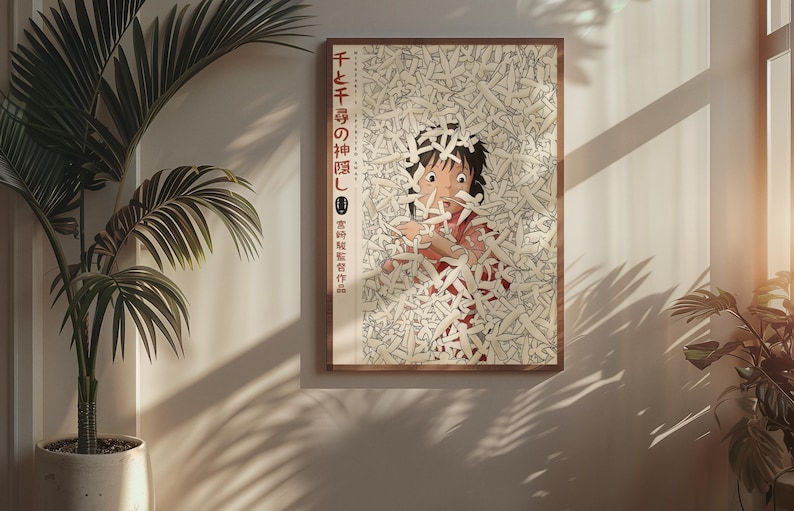 Puede incluir: P&oacute;ster enmarcado con un personaje de la pel&iacute;cula de animaci&oacute;n "El viaje de Chihiro". La obra de arte representa a una persona joven rodeada de objetos blancos con forma de papel. El p&oacute;ster est&aacute; en un marco de madera y cuelga de una pared.