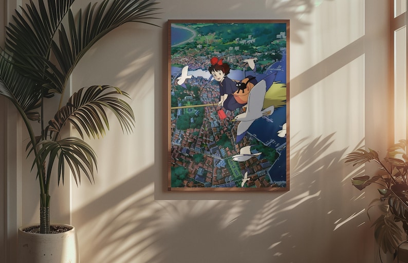 May include: A framed art print featuring a scene from an animated film. The artwork depicts a young girl with a red bow flying on a broom over a city, accompanied by a black cat and seagulls. The print is in a wooden frame.