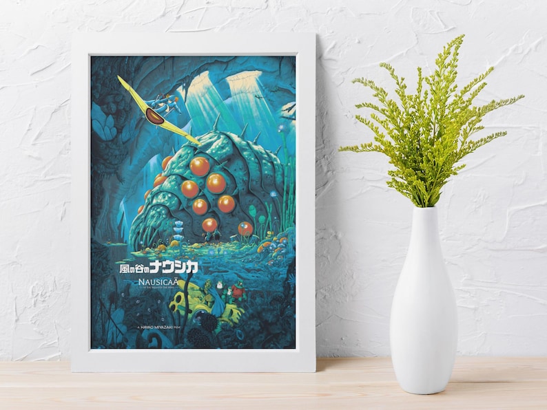 Puede incluir: P&oacute;ster enmarcado con una ilustraci&oacute;n de la pel&iacute;cula de animaci&oacute;n "Nausica&auml; del Valle del Viento". La obra de arte muestra una criatura gigante con forma de insecto en tonos azules y verdes, con esferas naranjas. Un planeador amarillo vuela por encima. El p&oacute;ster est&aacute; en un marco blanco.