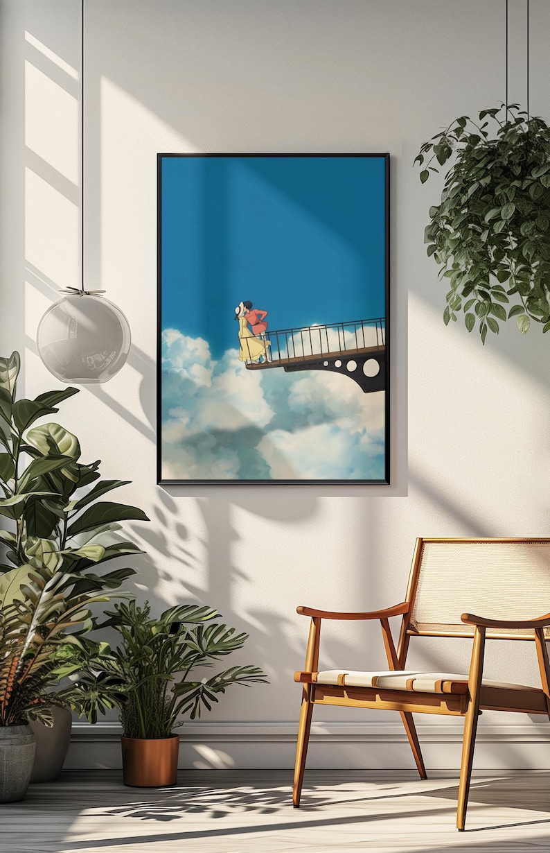 May include: Framed art print featuring a couple on a bridge above the clouds. The artwork has a blue sky background with white clouds. The couple is wearing red and yellow clothing. The print is in a black frame.