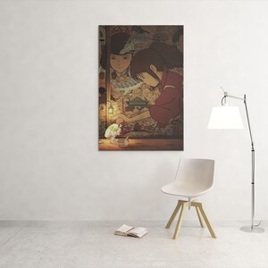 May include: A framed print depicting an anime scene with two women in traditional attire. One is holding a glowing object. The artwork has warm tones and is displayed on a white wall.