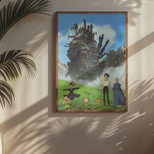 May include: A framed art print featuring a scene from the animated film, Howl's Moving Castle. The artwork depicts a large, fantastical castle, characters, and a green landscape under a blue sky. The frame is a warm brown color.