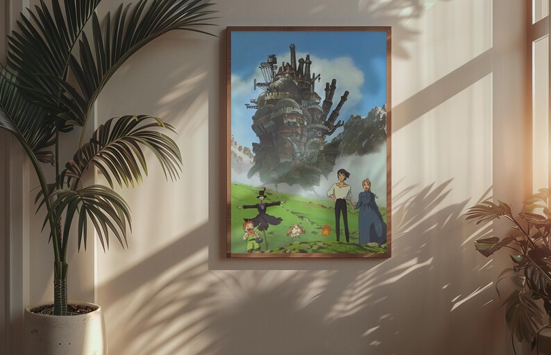 May include: A framed art print featuring a scene from the animated film, Howl's Moving Castle. The artwork depicts a large, fantastical castle, characters, and a green landscape under a blue sky. The frame is a warm brown color.