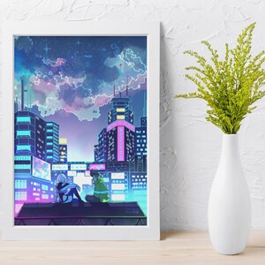 May include: A framed art print showing an anime-style cityscape at night. The artwork features two figures on a rooftop, with buildings lit in neon colours under a cloudy sky. A white vase with green foliage is to the right.