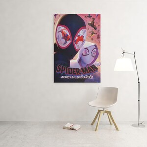 May include: A framed poster featuring Spider-Man and Spider-Gwen from the movie "Spider-Man: Across the Spider-Verse." The poster has a dark background with the title text in white and red. The image is hanging on a white wall.