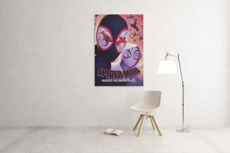 May include: A framed poster featuring Spider-Man and Spider-Gwen from the movie "Spider-Man: Across the Spider-Verse." The poster has a dark background with the title text in white and red. The image is hanging on a white wall.