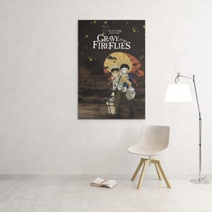 Puede incluir: Un p&oacute;ster de la pel&iacute;cula de animaci&oacute;n "La tumba de las luci&eacute;rnagas" cuelga de una pared blanca. El p&oacute;ster muestra a dos ni&ntilde;os bajo un paraguas amarillo, con el t&iacute;tulo de la pel&iacute;cula en texto blanco. Una silla blanca, una l&aacute;mpara y un libro est&aacute;n frente a la pared.