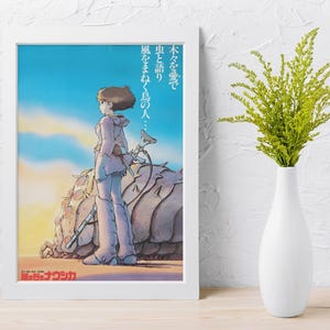 Puede incluir: Un p&oacute;ster enmarcado con una ilustraci&oacute;n de estilo anime. La obra de arte representa a una persona con ropa clara de pie junto a una gran criatura parecida a un insecto. El fondo muestra un cielo azul y un sol poniente. Se ve texto japon&eacute;s.