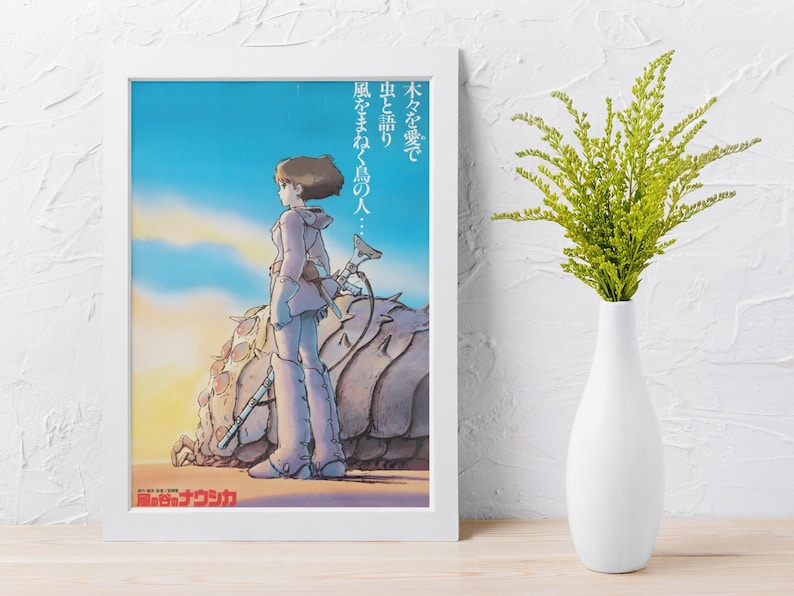 Puede incluir: Un p&oacute;ster enmarcado con una ilustraci&oacute;n de estilo anime. La obra de arte representa a una persona con ropa clara de pie junto a una gran criatura parecida a un insecto. El fondo muestra un cielo azul y un sol poniente. Se ve texto japon&eacute;s.