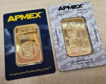 Puede incluir: Dos lingotes de oro, cada uno con un peso de 28,35 gramos, se muestran en su embalaje original. Las barras están estampadas con el logotipo de APMEX y otros detalles. Un paquete es azul marino y el otro es blanco.