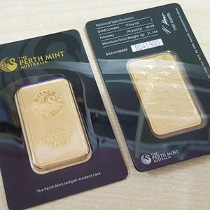 Pode incluir: Duas barras de ouro em embalagens inviol&aacute;veis da The Perth Mint Australia. Cada barra &eacute; retangular, com as palavras "1 Troy Ounce" e um logotipo. A embalagem inclui especifica&ccedil;&otilde;es t&eacute;cnicas, incluindo o n&uacute;mero da barra.