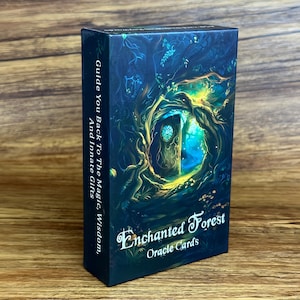 May include: A rectangular deck of Enchanted Forest Oracle Cards in a dark blue box. The front features a glowing tree hollow with a clock-faced door. The side text reads: Guide You Back To The Magic, Wisdom, And Innate Gifts in white font.