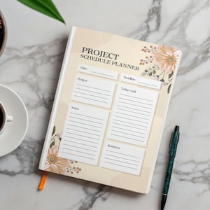 May include: A project schedule planner with floral accents and the text "PROJECT SCHEDULE PLANNER." The planner has sections for date, project, deadline, today's goal, notes, and resources. A cup of coffee, a pen, and a plant are also visible.