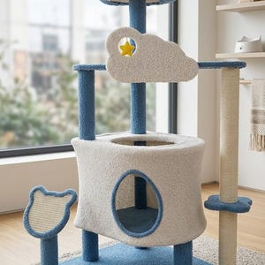 Könnte beinhalten: Ein mehrstöckiger Katzenbaum mit einer blauen sechseckigen Basis, einem zentralen weißen zylindrischen Versteck mit ovaler Öffnung und blauen Stützpfosten. Er umfasst eine obere blaue Sitzstange, einen weißen wolkenförmigen Ausschnitt mit einem hängenden gelben Stern und ein kleines bärenförmiges Kratzpad.