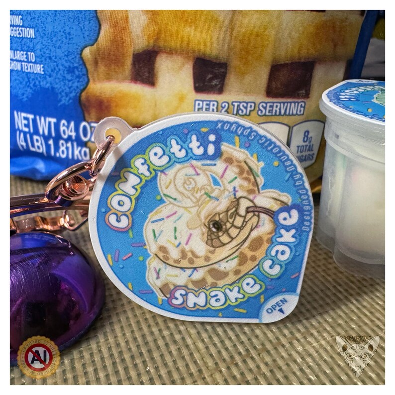 Llavero antiestrés con forma de taza de pudín de confeti Snake Cake