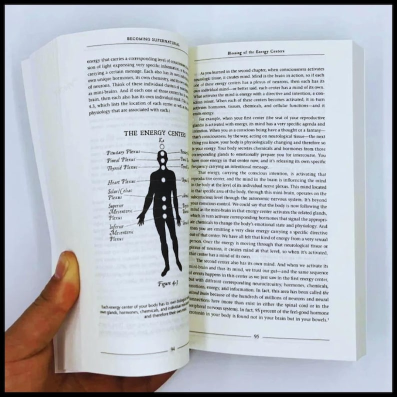 May include: Open book showing text and a diagram of the human body's energy centres. The diagram is a black silhouette with labelled points. The text discusses consciousness and energy.