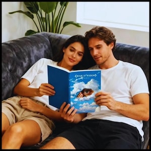May include: A couple is seated on a gray couch, reading a book titled "Book of Wisdom." The book cover features a blue sky with clouds and an eye. Both are wearing white t-shirts.