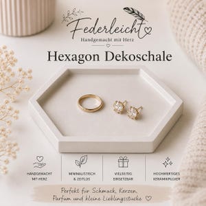 Può includere: Un vassoio decorativo esagonale bianco con il testo "Federleicht" e "Hexagon Dekoschale". Il vassoio contiene un anello d'oro e due orecchini a bottone d'oro. Il vassoio è progettato per contenere gioielli, candele, profumi e piccoli oggetti.