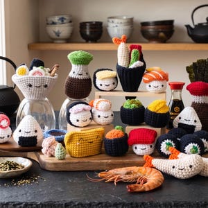 Könnte beinhalten: Eine Sammlung verschiedener gehäkelter Sushi- und japanischer Lebensmittel, die jeweils ein kleines aufgesticktes lächelndes Gesicht haben. Das Set umfasst Nigiri, Maki-Rollen, Onigiri und eine Sojasaucenflasche auf einem Holzbrett.