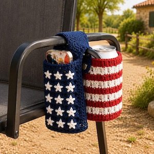 May include: A double-pocket crochet chair armrest organizer featuring a navy blue section with white stars and a red and white striped section. The organizer is draped over a black chair arm, holding a smartphone in one pocket and a silver beverage can.