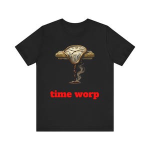 May include: Black t-shirt featuring a surrealist design of a melting clock with the text "time worp" in red. The clock has a gold frame and a white clock face. The design is printed on a black t-shirt.