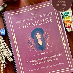 May include: A coil-bound book titled The Resourceful Witch's Grimoire: Creating everyday magick with what you already have, written and designed by Shelby Masi. The cover is deep purple with a gold-toned illustration of a person in a hat.