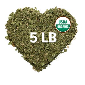 May include: A heart-shaped pile of dried green herbs with the text 5 LB printed in white and a circular USDA ORGANIC seal in the upper right corner. The herbs are a mix of dark and light green leaves and small stems arranged in a heart shape.
