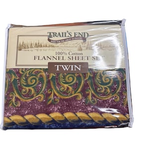 May include: A Twin-size Trail's End 100% cotton flannel sheet set in a clear plastic package. The sheet set features a burgundy, green, and gold pattern. The packaging includes the text "Made for the Great Outdoors."