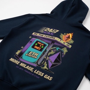 Könnte beinhalten: Ein marineblauer Kapuzenpullover mit einer Grafik auf der Rückseite, die eine Zapfsäule mit der Aufschrift ETH STATION zeigt. Das Design enthält den Text 24/7 GAS, BE THE FUTURE und MORE MILAGE, LESS GAS sowie ein brennendes Ethereum-Logo.