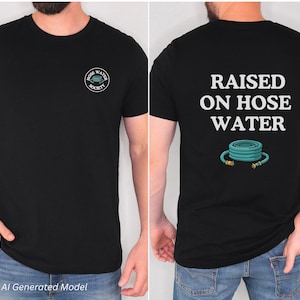 Op de afbeelding: Een zwart t-shirt met een klein rond logo op de borst met de tekst Hose Water Society en een afbeelding van een opgerolde slang. De achterkant toont de tekst Raised On Hose Water boven een afbeelding van een opgerolde blauwgroene tuinslang.