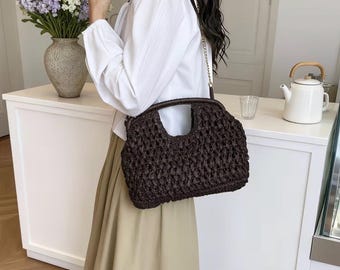 Elegante bolso de mano de paja marrón tejido a mano con asa calada.