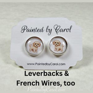 May include: A pair of silver leverback earrings with a white background and a cartoon image of a small, light brown dog. The earrings are for sale by Painted by Carol, www.PaintedbyCarol.com. Leverbacks & French Wires, too. PaintedbyCarol.com