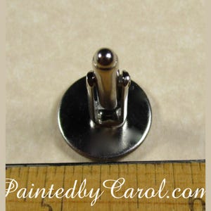 May include: Silver cufflinks with a round, silver-toned face. The cufflinks have a hinged back.