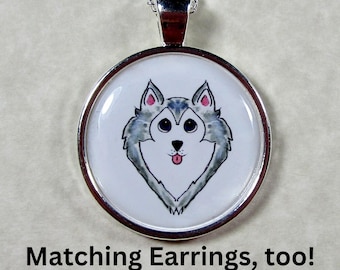 May include: Silver necklace with a round pendant featuring a cartoon husky dog with gray fur, pink ears, and a black nose. The dog is sticking its tongue out. The pendant is on a white background.