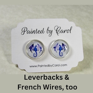 May include: A pair of silver earrings with a purple and blue dragon design on a white card with the text "Painted by Carol" and "www.PaintedbyCarol.com". The card also says "Leverbacks & French Wires, too".