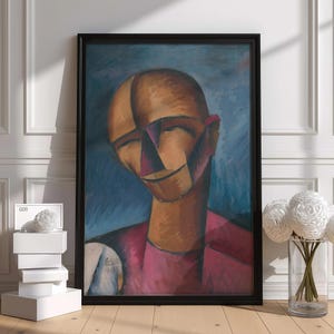 Peut inclure: Une peinture encadrée représentant une tête humaine stylisée et abstraite au teint bronzé, aux traits géométriques et vêtue d'un vêtement rose foncé sur fond bleu. L'œuvre comporte une signature et une date dans le coin inférieur gauche.