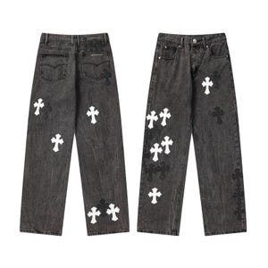 Pantalones vaqueros unisex de mezclilla lavada estilo streetwear con parche cruzado y corte holgado de algodón.