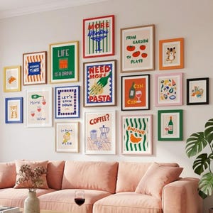 May include: A living room featuring a light pink sofa, a wooden coffee table, and a gallery wall of framed art prints. The prints display colourful illustrations and text, such as "More Time", "Life is a Drink", and "Need More Pasta". A potted plant is in the corner.