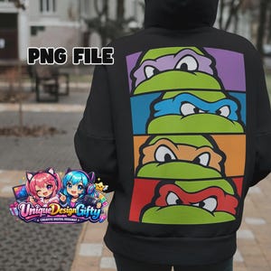 Puede incluir: Sudadera con capucha negra con un gráfico colorido de las caras de las Tortugas Ninja. El diseño presenta las máscaras de los ojos de las tortugas en morado, azul, naranja y rojo. La sudadera tiene un corte holgado y una capucha.