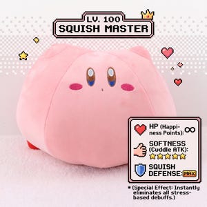 Könnte beinhalten: Ein rosa Plüschtier in Form eines Charakters mit großen Augen und einem lächelnden Gesichtsausdruck. Der Text "LV. 100 SQUISH MASTER" befindet sich über der Figur. Zusätzlicher Text beschreibt die Weichheit und Verteidigung des Spielzeugs.