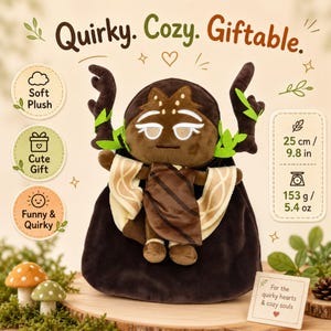 Op de afbeelding: Een zachte pluche pop met een bruin hoofd, geweien en een donkerbruine cape. De pop is 25 cm hoog en weegt 153 g. De tekst op de afbeelding luidt "Quirky. Cozy. Giftable."