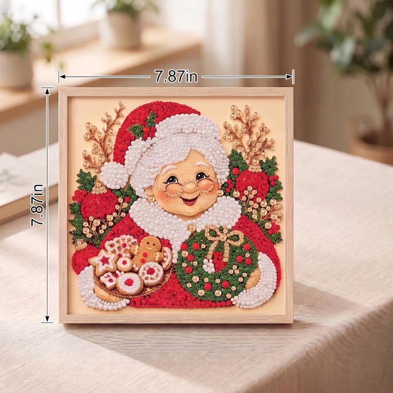 May include: A square framed diamond painting of Mrs. Claus wearing a red hat and white trim, holding a plate of cookies and a green wreath. The artwork features red, green, and white beads, measuring 7.87 inches by 7.87 inches as indicated by arrows.