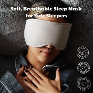 Puede incluir: Una m&aacute;scara para dormir de color beige claro cubre los ojos de una persona. La m&aacute;scara est&aacute; hecha de un material suave y transpirable, dise&ntilde;ada para personas que duermen de lado. El texto en la imagen dice "Soft, Breathable Sleep Mask for Side Sleepers". La imagen tambi&eacute;n incluye etiquetas veganas y hechas a mano.