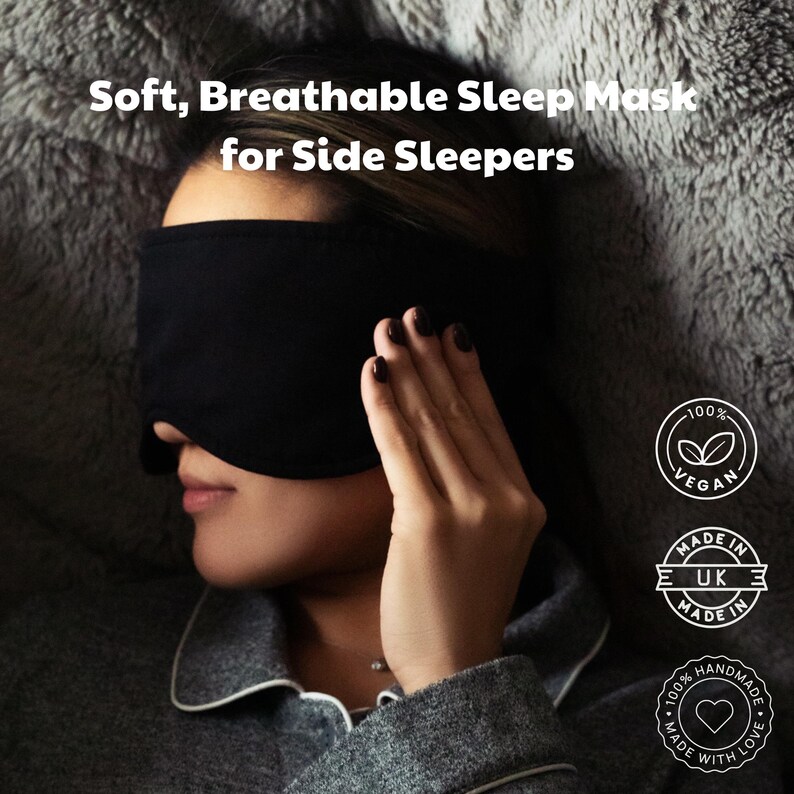 Pu&ograve; includere: Una mascherina per dormire nera tinta unita con il testo Soft, Breathable Sleep Mask for Side Sleepers. A destra sono visibili tre badge circolari con il testo 100% Vegan, Made in UK e Handmade with Love, insieme a icone di foglie e cuori.