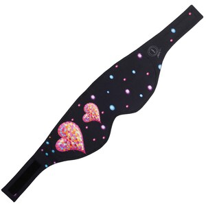 May include: Black sleep mask with a colorful heart design and polka dots. The mask has a hook and loop closure and is designed to block out light. The hearts are filled with pink, orange, and yellow dots.