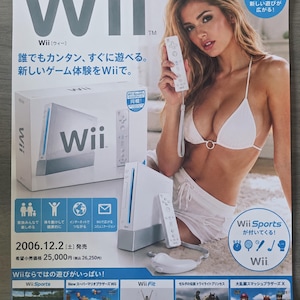May include: A promotional poster for the Nintendo Wii console featuring the white Wii console, a Wii Remote, and a Nunchuk. The poster displays the Wii logo, Japanese text, and images of various games including Wii Sports, New Super Mario Bros. Wii, Wii Fit, The Legend of Zelda: Twilight Princess, and Super Smash Bros. Brawl.