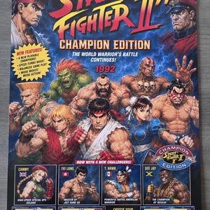 Op de afbeelding: Een Street Fighter II' Champion Edition poster met kleurrijke illustraties van diverse personages waaronder Ryu, Chun-Li en M. Bison. De tekst bevat "The #1 Arcade Smash Is Back!", "1992" en "Super Nintendo Entertainment System".
