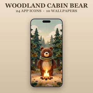 May include: A smartphone displaying a digital illustration of a brown bear wearing a green scarf standing before a campfire in a forest. The text WOODLAND CABIN BEAR 24 APP ICONS 10 WALLPAPERS is printed above the phone screen on a beige background.