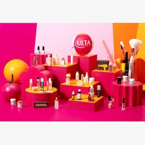 May include: A vibrant display of beauty products, including nail polish, skincare, and makeup, arranged on pink and orange platforms. The ULTA Beauty logo is prominently featured. Various cosmetic items are showcased, creating a colorful and appealing presentation.